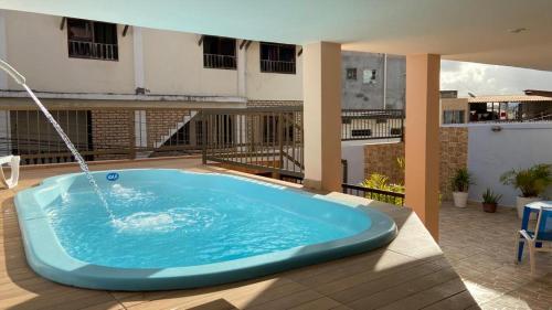 uma grande banheira azul sentada no topo de um pátio em Hostel Salvador Orquídeas em Salvador