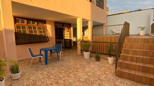 eine Terrasse mit einem blauen Tisch und Stühlen sowie ein Haus in der Unterkunft Hostel Salvador Orquídeas in Salvador