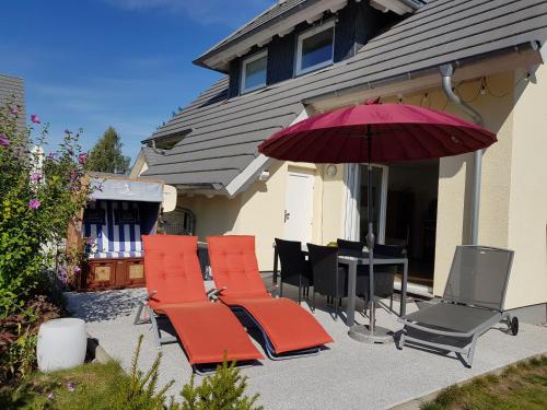 a group of chairs and a table with an umbrella at Kapitänsresidenz - Haus direkt am Wasser in Ueckeritz