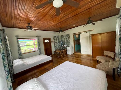 1 dormitorio con 2 camas y ventilador de techo en Sea n sun Guest House en Caye Caulker