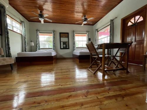 a living room with a table and two beds at Sea n sun Guest House in Caye Caulker