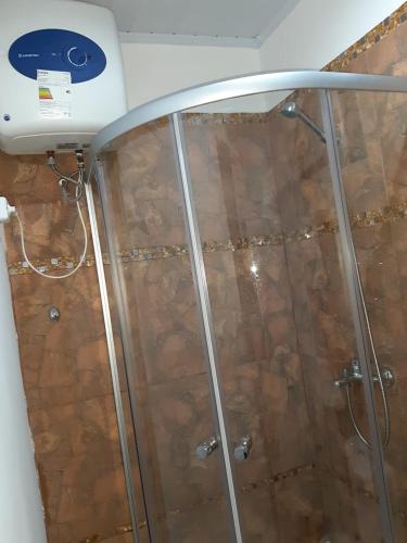 a shower with a glass door and a ceiling at Casa Containers Se RESERVA con SEÑA UTE APARTE in San Luis