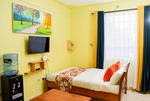 a small bedroom with a bed and a television at Naivasha Southlake apartments in Naivasha