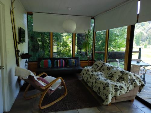 sala de estar con sofá y silla en Cabañas Nordic lodge en Chillán
