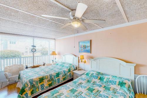 a bedroom with two beds and a ceiling fan at Shorely Suite in Atlantic Beach