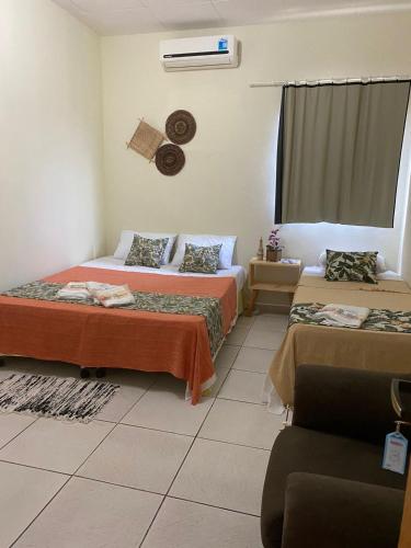 Zimmer mit 2 Betten und einem Fenster in der Unterkunft Bom Sossego Pousada DG in Delmiro Gouveia