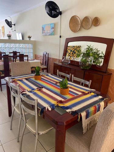 a dining room table with a colorful table cloth on it at Bom Sossego Pousada DG in Delmiro Gouveia