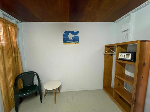 a small room with a chair and a shelf at Sea n sun Guest House in Caye Caulker