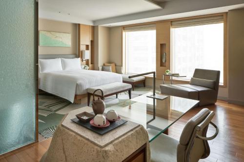 a bedroom with a bed and a living room at InterContinental Hotel Osaka by IHG in Osaka