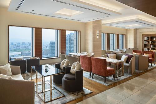 a hotel lobby with chairs and tables and windows at InterContinental Hotel Osaka by IHG in Osaka