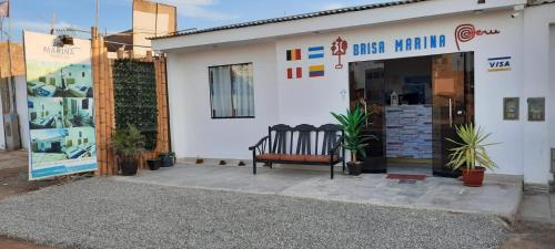 a bench sitting outside of a white building at Hostal Brisa Marina in Paracas