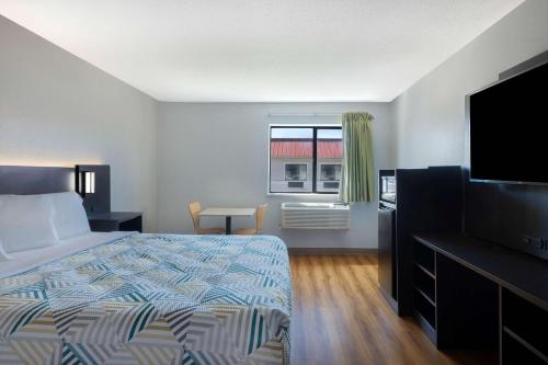 um quarto com uma cama e uma televisão de ecrã plano em Motel 6-Shepherdsville, KY Louisville South em Shepherdsville