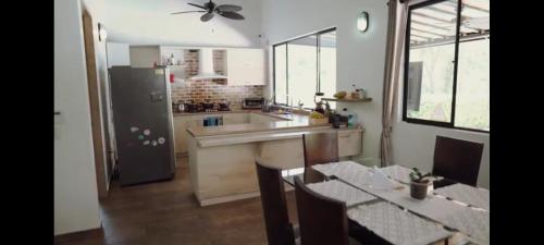 Il comprend une cuisine équipée d'un réfrigérateur et d'une table avec des chaises. dans l'établissement ENTREPALMAS, à San Jerónimo