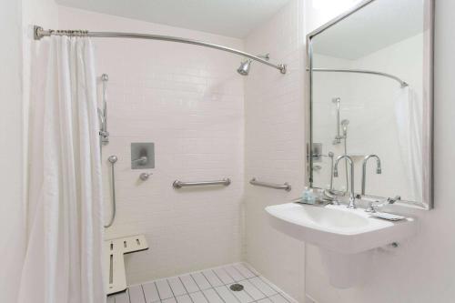 uma casa de banho branca com um lavatório e um chuveiro em Wyndham Garden Manassas em Manassas