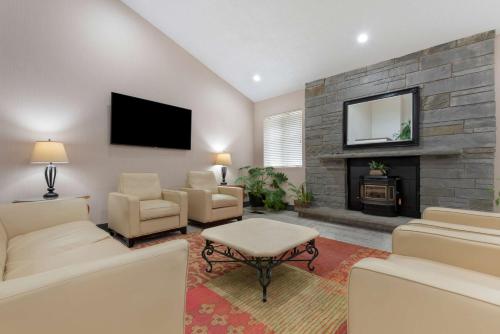 a living room with a tv and a fireplace at Best Western University Inn in Ithaca