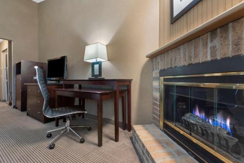 a hotel room with a desk and a fireplace at Best Western University Inn in Ithaca