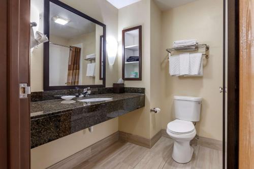 a bathroom with a toilet and a sink and a mirror at Best Western PLUS Sparta Trail Lodge in Sparta
