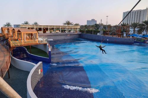 a man on a rope swing in a swimming pool at Radisson Blu Hotel & Resort, Abu Dhabi Corniche in Abu Dhabi
