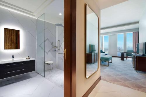 a bathroom with a sink and a mirror at Wyndham Grand Doha West Bay Beach in Doha