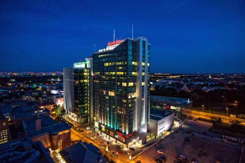 ein hohes Gebäude mit Lichtern in der Nacht in der Unterkunft Andersia Hotel & Spa Poznan, a member of Radisson Individuals in Posen