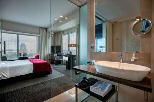 a bathroom with a sink and a bed and a tub at Andersia Hotel & Spa Poznan, a member of Radisson Individuals in Poznań
