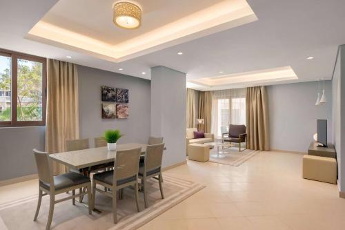 a dining room and living room with a table and chairs at Wyndham Residences The Palm in Dubai