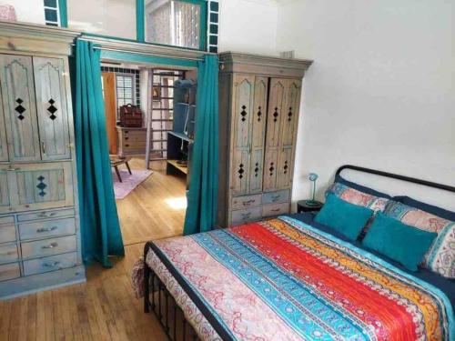 a bedroom with a bed and some wooden cabinets at Boho hip bungalow in Old Bisbee in Bisbee