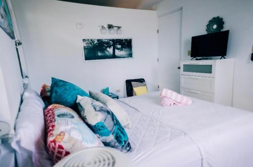 a bedroom with a white bed with pillows on it at Casa Del Mar !!! Ocean front villa in Aguada