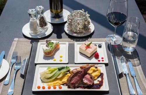 two plates of food on a table with wine glasses at Seehotel Sternen in Luzern