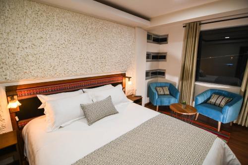 um quarto de hotel com uma cama e duas cadeiras azuis em Cielo & Sal Hotel em Uyuni