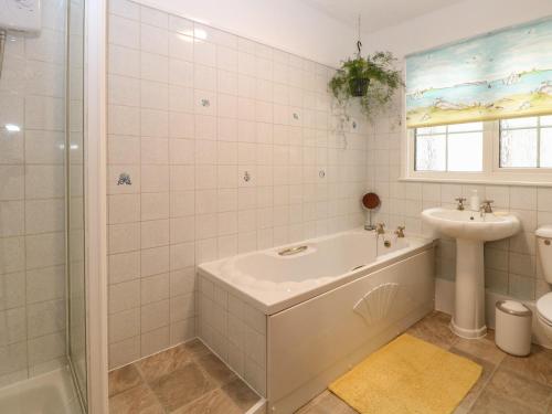 a bathroom with a tub and a sink and a toilet at Dove's Nest in Great Yarmouth