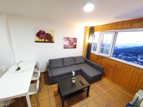 un soggiorno con un divano e un tavolo di Maribel ERB Alojamientos a Sierra Nevada