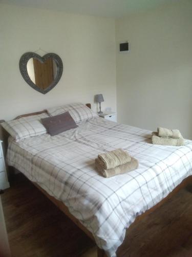 a bedroom with a bed with two towels on it at The Retreat in Niton