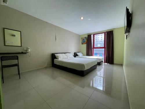 a hotel room with two beds and a window at Parc Hotel Pelangi Damansara in Kota Damansara