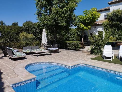 uma piscina em frente a uma casa em CASA RURAL HUERTA DEL MEDIO em Granada