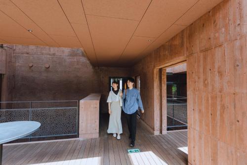 a man and a woman walking down a hallway at SEKIYA RESORT Galleria Midobaru in Beppu