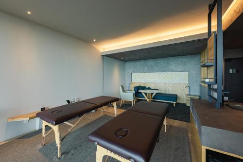 a living room with two benches and a table at SEKIYA RESORT Galleria Midobaru in Beppu
