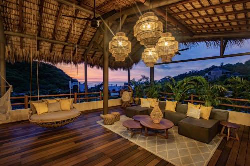 a living room with a couch and chairs and chandeliers at Hotel Casa Bocana in Santa Cruz Huatulco