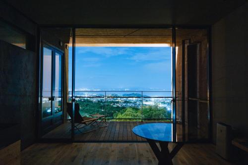 a room with a view of a balcony with a table at SEKIYA RESORT Galleria Midobaru in Beppu
