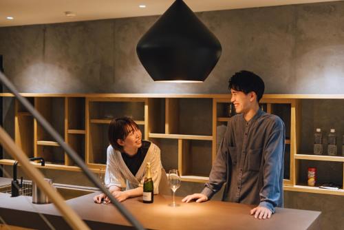 a man and a woman sitting at a table with wine glasses at SEKIYA RESORT Galleria Midobaru in Beppu