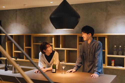 a man and a woman sitting at a table with wine glasses at SEKIYA RESORT Galleria Midobaru in Beppu