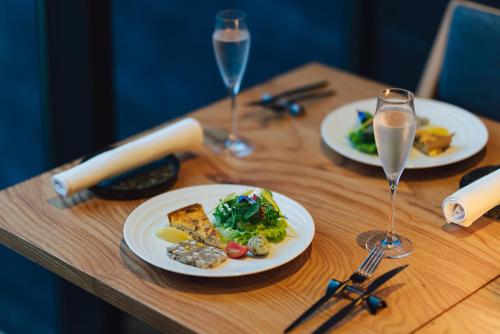 a wooden table with plates of food and glasses of wine at SEKIYA RESORT Galleria Midobaru in Beppu