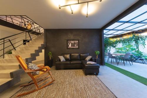 sala de estar con sofá y escalera en Hostal Casa Mosaiko Primer Parque-Laureles, en Medellín