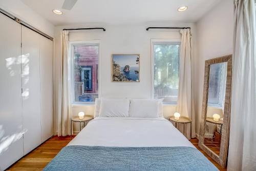 a bedroom with a large bed and two windows at Earn Your Vacation Stripes in Austin