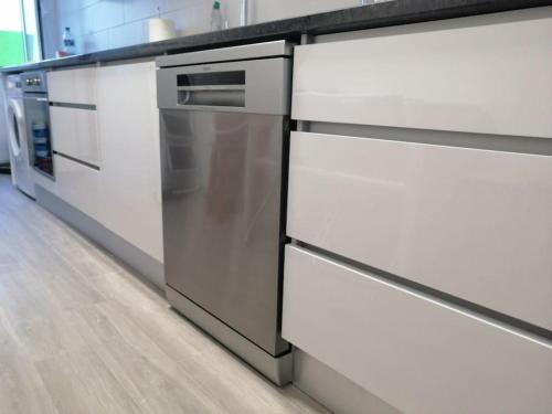 Una cocina con gabinetes blancos y encimera. en Casa Peixe Nazare, en Nazaré