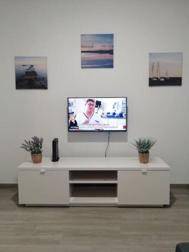 a white entertainment center with a tv on a white wall at Casa Peixe Nazare in Nazaré