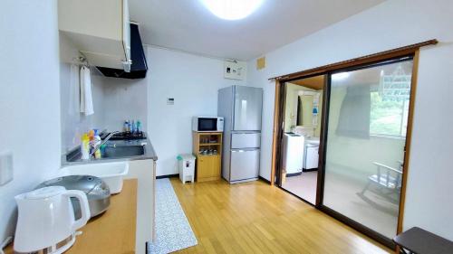 a kitchen with a sink and a refrigerator at Iruma INN in Minamiizu
