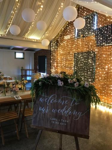 a table with a sign in a room with lights at Bridgehouse Lodge in Warkworth