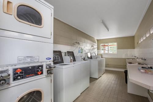 a laundry room with white washers and dryers at River Retreat Home & Holiday Park in Tweed Heads
