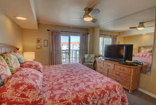 a bedroom with a bed and a flat screen tv at El Matador 165 - Beautiful unit with great view of the Gulf in Fort Walton Beach
